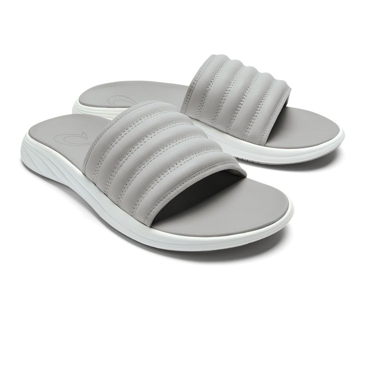 Drawing inspiration from sporty sneakers, the Komo Slide combines the ease of a slip-on with the comfort of OluKai. Featuring a cushioned footbed and a snug, water-resistant strap, this slide is designed for effortless entry and superior comfort. The name 'Komo,' meaning "to enter" or "to go into," aptly reflects the slide's readiness to accompany you in every step of your day, whether you're hitting the beach or the streets. Key Features: Water-Repellent Material: Crafted with water-repellent s Fade-resistant Outdoor Slip-on Slides, Outdoor Synthetic Slip-on Slides, Non-slip Gray Synthetic Slides, Gray Synthetic Slip-on Slides, Sporty Synthetic Slip-on Slides, Relaxing Backyard, Mens Slide Sandals, Beach Slides, Sporty Sneakers