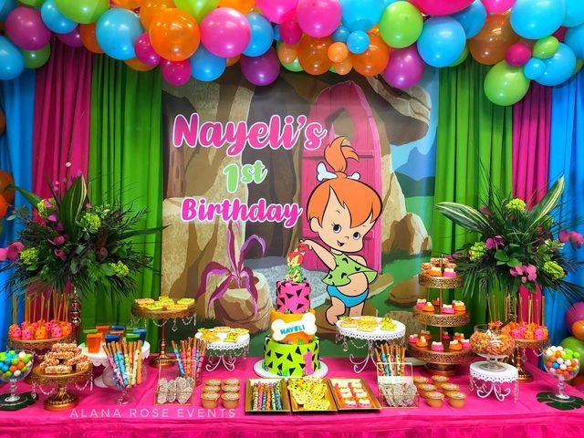 a birthday party with balloons and decorations on the table, including an image of cartoon characters