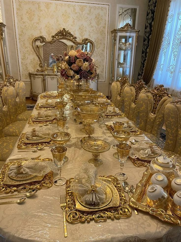 a dining room table set with gold plates and place settings