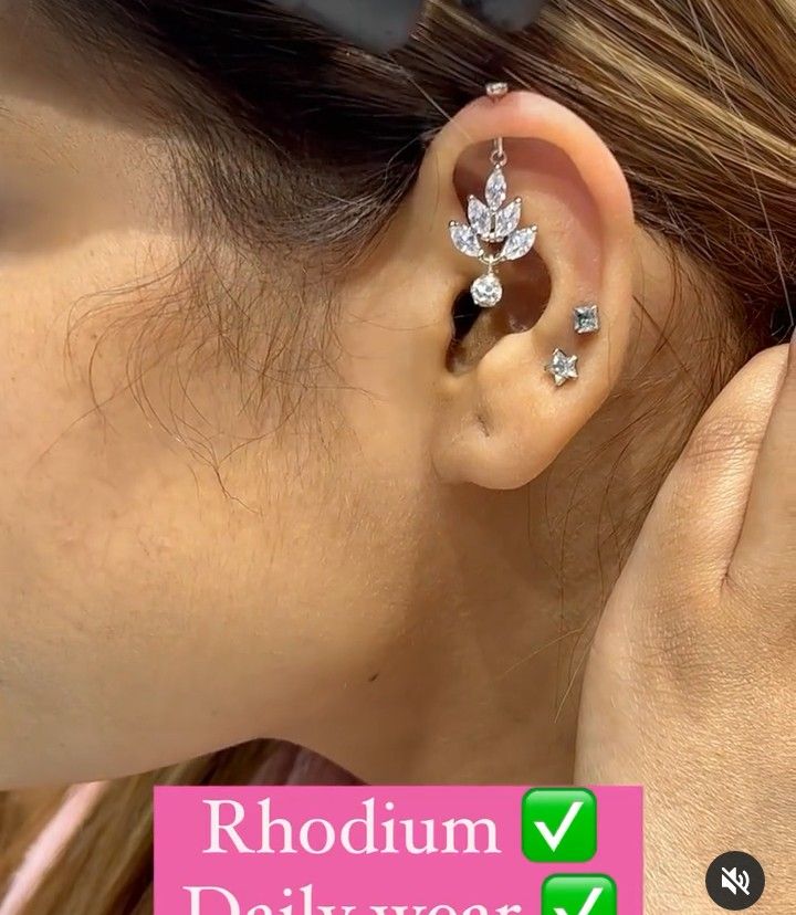 a woman wearing a pair of ear piercings on her left ear with the word rhodium deliverr below it