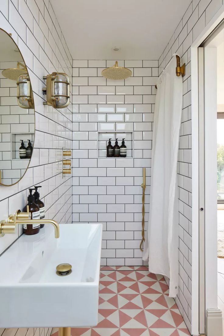 a white tiled bathroom with gold accents