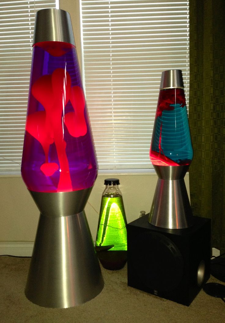 three different colored vases sitting next to each other on the floor in front of a window