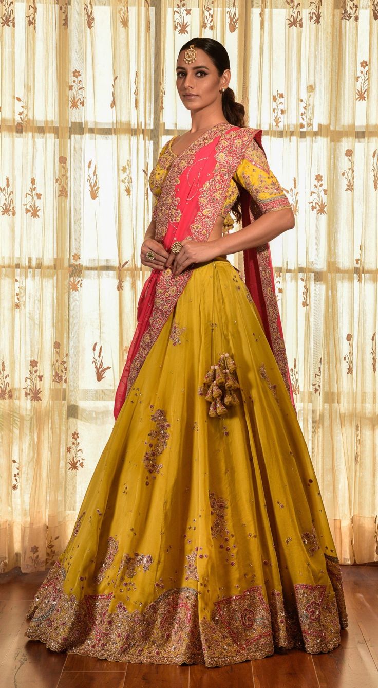 Editor's Note This set features a gorgeous greenish-yellow organza kalidar lehenga with tilla border, an organza blouse, and a red chiffon dupatta with jaal and tilla border. The intricate detailing of tilla work adds a touch of elegance to the ensemble. Fabric: Organza, chiffon Color: Yellow, red, green Components: Lehenga, blouse and dupatta Occasion: Haldi mehndi Disclaimer: Product color may slightly vary due to photographic lighting sources or your monitor setting. Care: Dry clean only Abou Transitional Yellow Chanderi Choli, Yellow Silk Lehenga With Resham Embroidery, Yellow Organza Lehenga With Resham Embroidery, Yellow Salwar Kameez For Reception And Festivals, Festive Yellow Salwar Kameez For Reception, Transitional Yellow Choli With Dupatta, Yellow Anarkali Choli With Sheer Dupatta, Yellow Organza Sharara For Navratri, Traditional Yellow Salwar Kameez For Reception