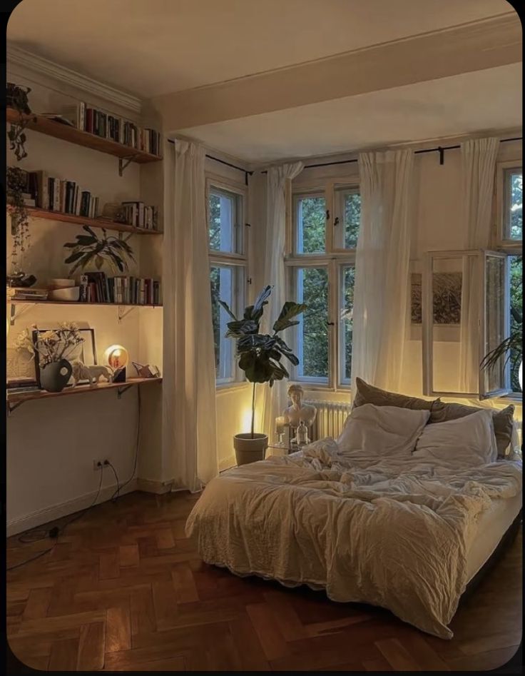 a bed in a room with lots of windows and plants on the wall next to it