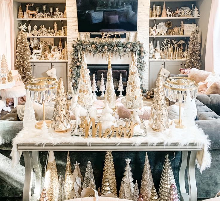 a living room decorated for christmas with gold and white decorations on the fireplace mantel