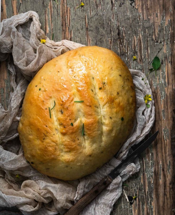 a loaf of bread sitting on top of a piece of cloth next to a knife