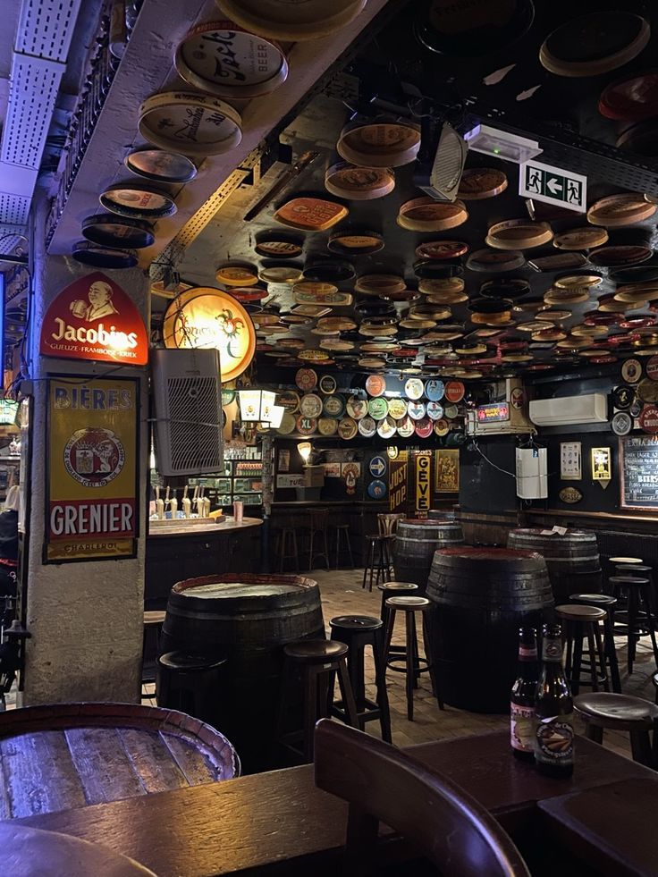 the interior of a bar with lots of wooden barrels hanging from the ceiling