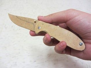 a hand holding a small wooden knife in it's right hand and the blade is missing