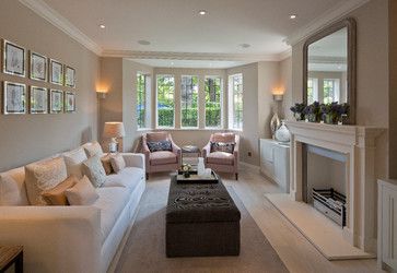 a living room filled with furniture and a fire place in front of a mirror on the wall