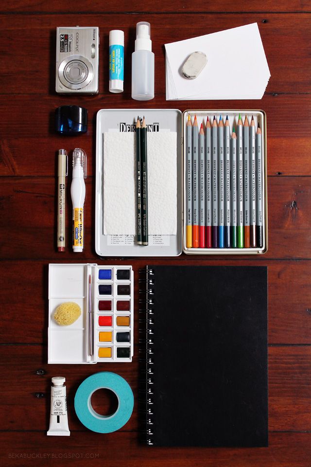 an assortment of art supplies laid out on a wooden table with pens, markers, and washi tape