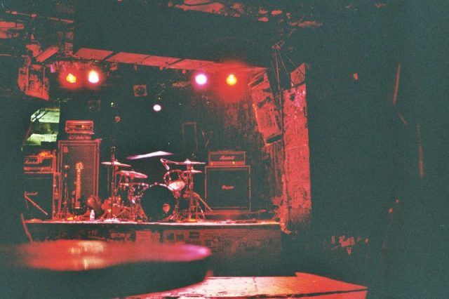 the stage is set up for a concert with red lights and drum sticks in front of it