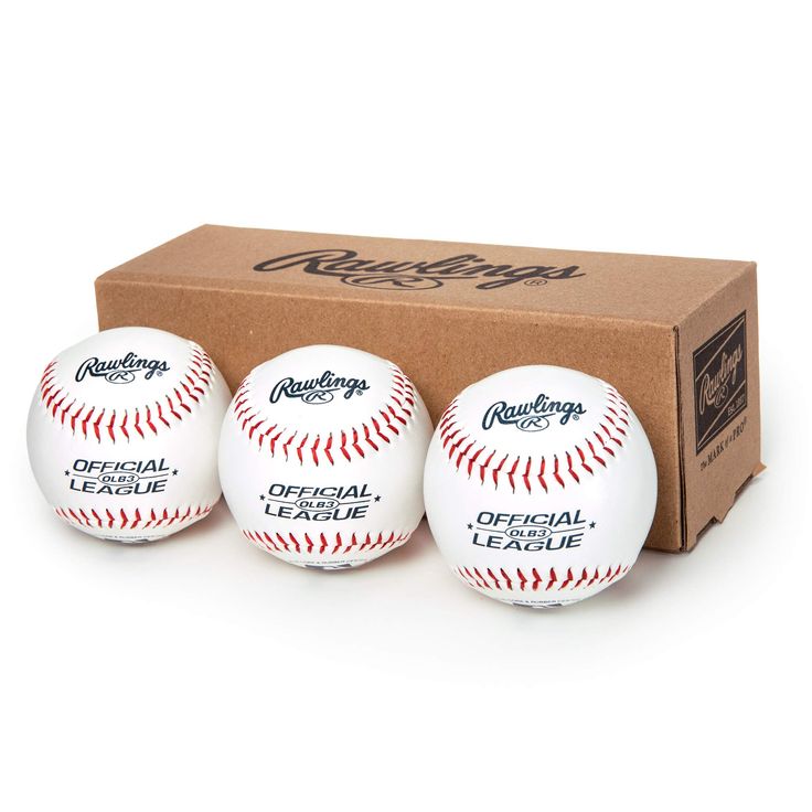 three baseballs sitting in front of a cardboard box