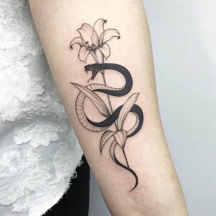 a snake and flower tattoo on the arm