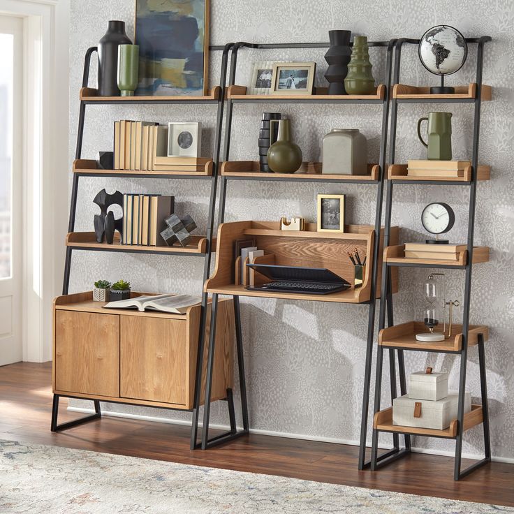 a book shelf with books, vases and other items on it in front of a window