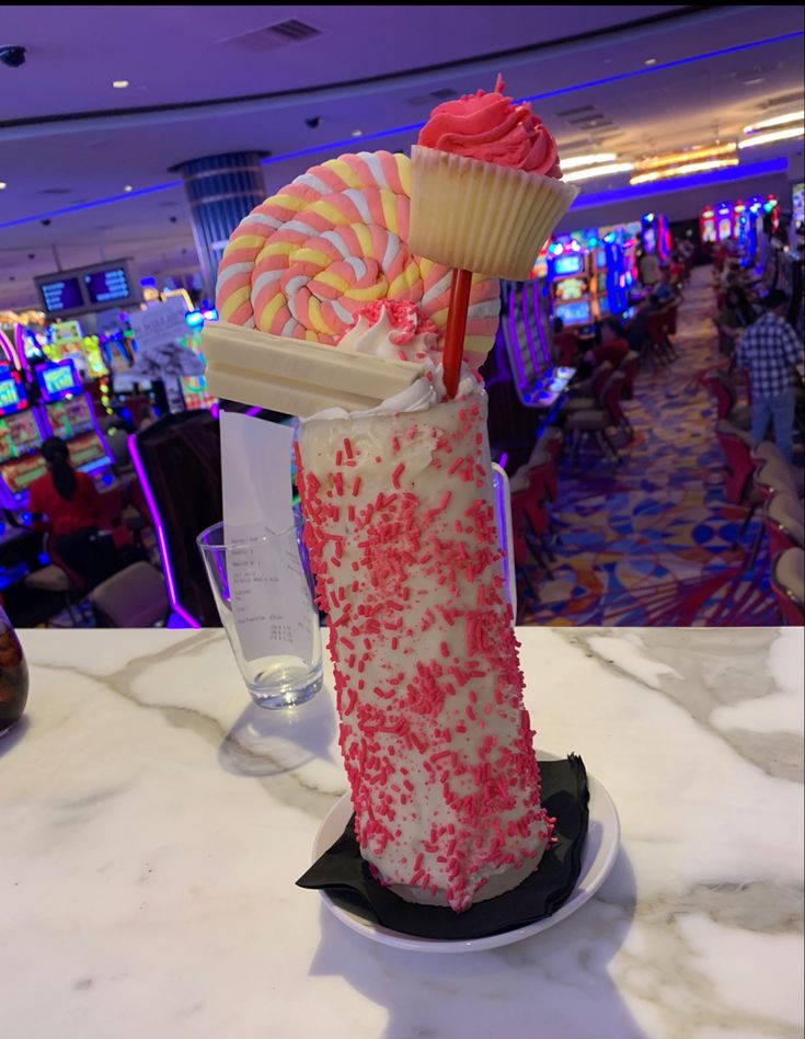 there is a cupcake and some candy on top of a table in a restaurant