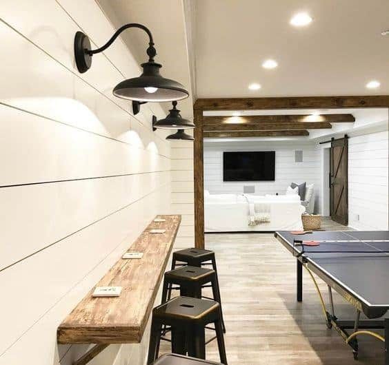 an indoor ping pong table in a room with white walls and wood flooring