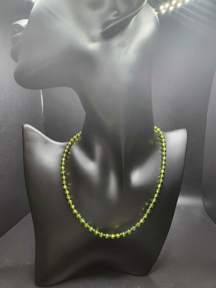 Orunmila Spiritual Orisha is surrounded with the essence of beautiful string crystal beads in the color of green and yellow beaded on silver chain which features a handcrafted providing a sophisticated and balanced design. The chain is crafted from sterling silver and secured with a lobster clasp closure, completing the piece with a touch of elegance. Spiritual Yellow Hand-strung Necklaces, Balanced Design, Green And Yellow, Chain Styles, Green Colors, Crystal Beads, Lobster Clasp, Silver Chain, Necklace Lengths