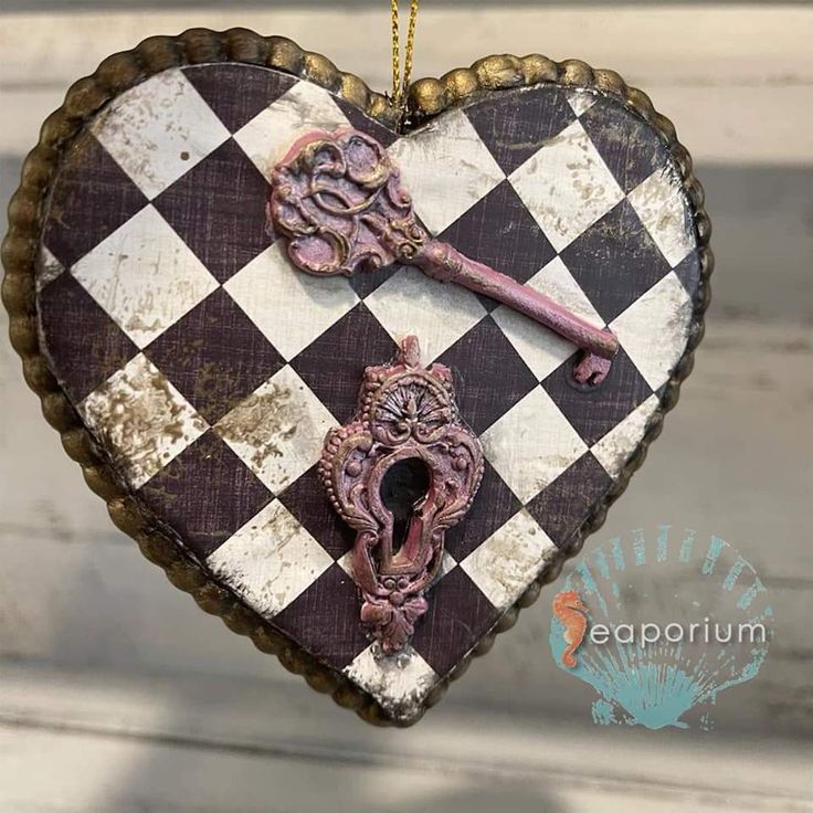 a heart shaped ornament with an ornate key hanging from it