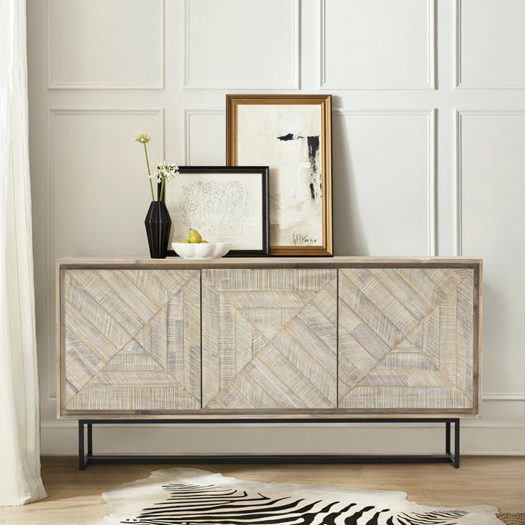 a zebra print rug is on the floor next to a wooden cabinet and framed pictures