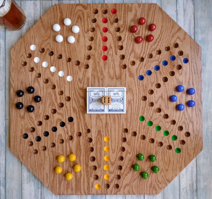 a wooden board game set up with several different colored beads and one hundred dollar bill