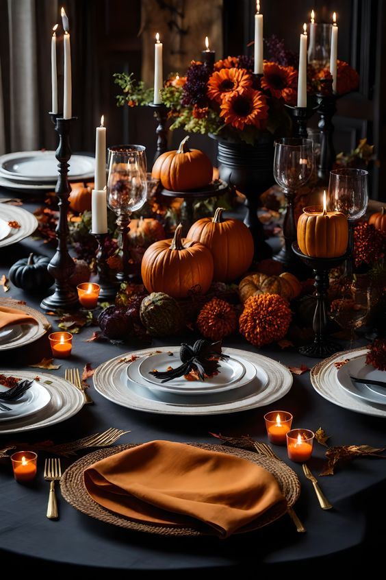 a table set with plates, candles and pumpkins