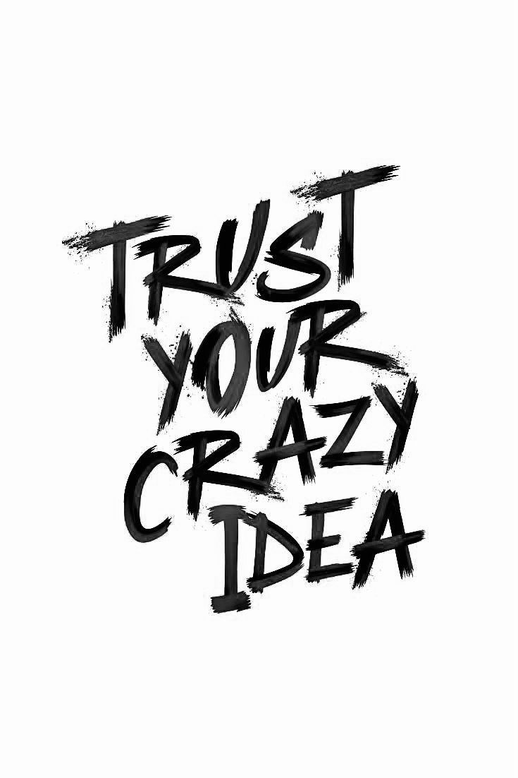 the words trust your crazy idea written in black ink