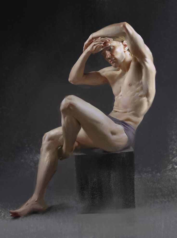 a naked man sitting on top of a black box with his hands behind his head