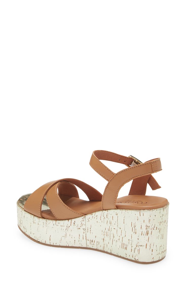 Soft leather straps crisscross at the toe of this Italian-crafted sandal elevated on a lacquered cork-wrapped platform wedge. 3 1/4" heel; 2" platform Adjustable strap with buckle closure Cushioned footbed Leather upper and lining/synthetic sole Made in Italy Chic Cork Wedge Sandals With Open Toe, Chic Open Toe Cork Wedge Sandals, Chic Cork Wedge Sandals For Spring, Platform Cork Wedge Sandals For The Beach, Chic Cork Sandals With Open Toe, Brown Cork Wedge Sandals For Summer, Summer Brown Cork Wedge Sandals, Chic Cork Sandals With Round Toe, Chic Cork Sandals For Spring