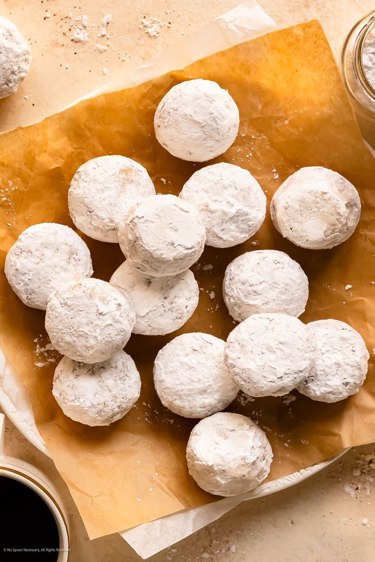 some doughnuts are sitting on a piece of parchment paper