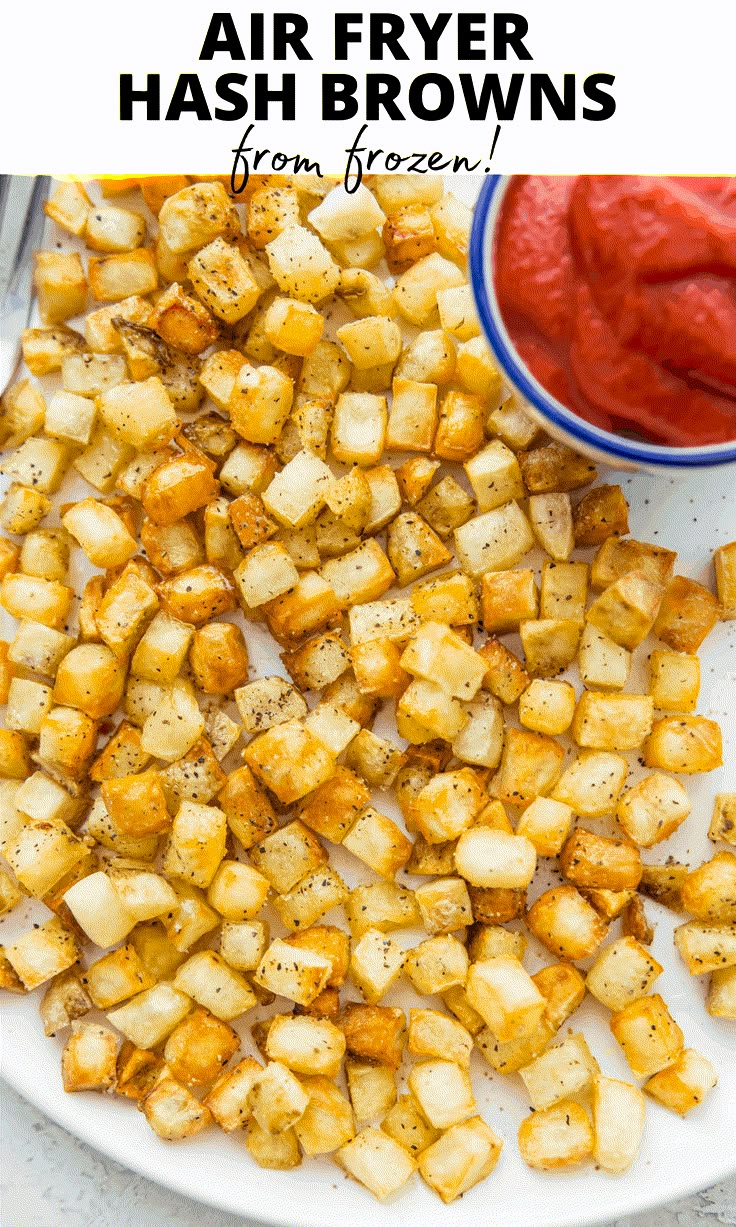 air fryer hash browns on a white plate with ketchup in the background