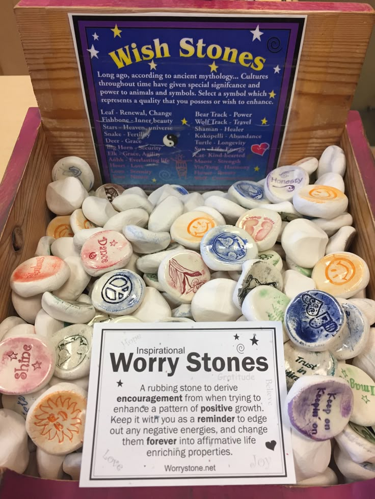 a wooden box filled with lots of different colored stones and a sign that says wish stones