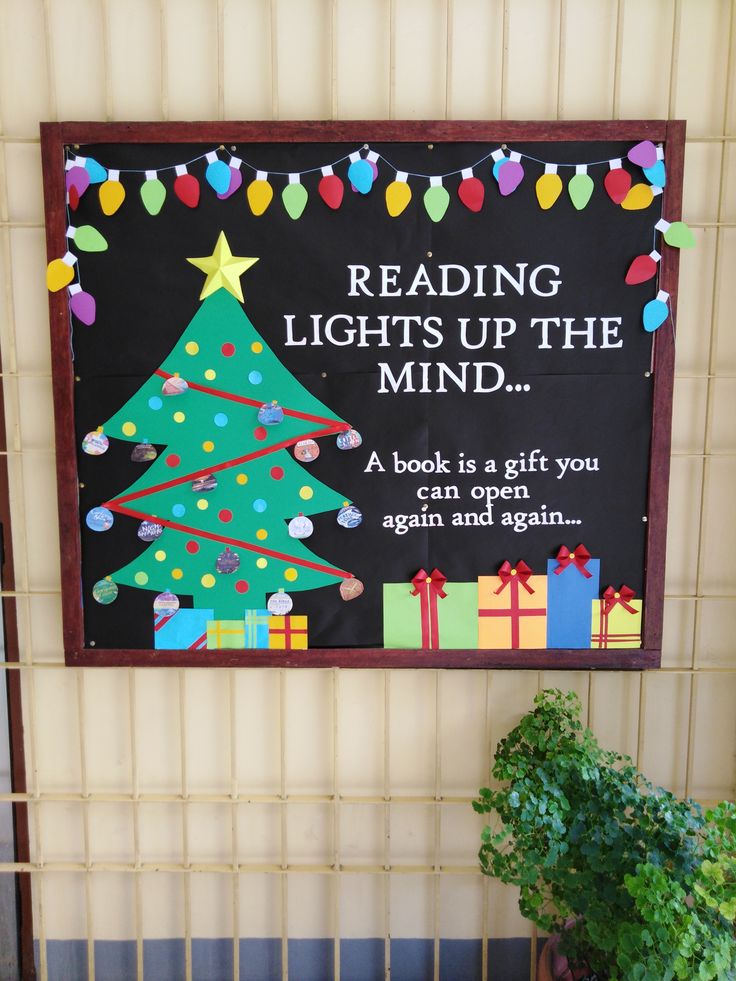 a sign that reads reading lights up the mind with a christmas tree and presents on it