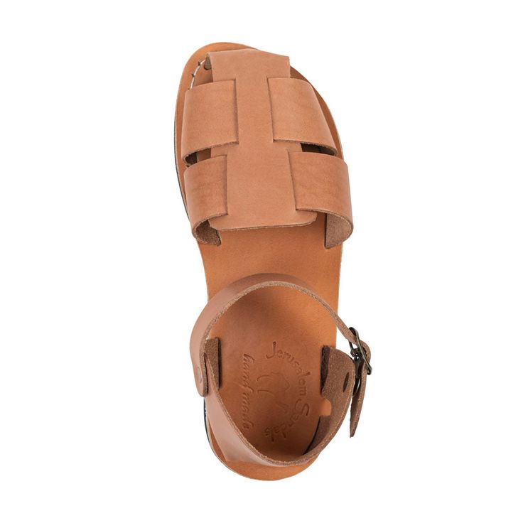 Embrace style and reliable comfort with the Gemma sandal, featuring a fashionable fisherman sandal silhouette crafted from tan full-grain leather. Enjoy a customized fit with the adjustable ankle strap and buckle closure in matching hardware. Gemma, like all Jerusalem Sandals, prioritizes comfort, with a leather sole that molds to your feet and a polyurethane outsole ensuring all-day comfort from city streets to nature trails. These durable leather sandals are lightweight and flexible, ensuring Brown Slingback Sandals With Buckle For Vacation, Brown Slingback Sandals With Buckle Closure For Vacation, Brown T-strap Sandals With Adjustable Strap For Vacation, Brown T-strap Footbed Sandals For Summer, Brown Leather Sport Sandals For Vacation, Brown Ankle Strap Sport Sandals For Beach, Brown Sport Sandals With Ankle Strap For Beach, Adjustable Sandals With Leather Lining For Vacation, Brown Leather Strap Closed Toe Sandals