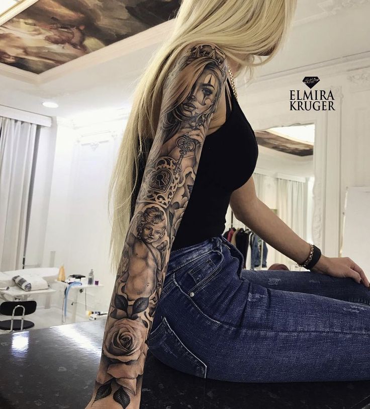 a woman sitting on top of a counter with a tattoo on her arm and leg