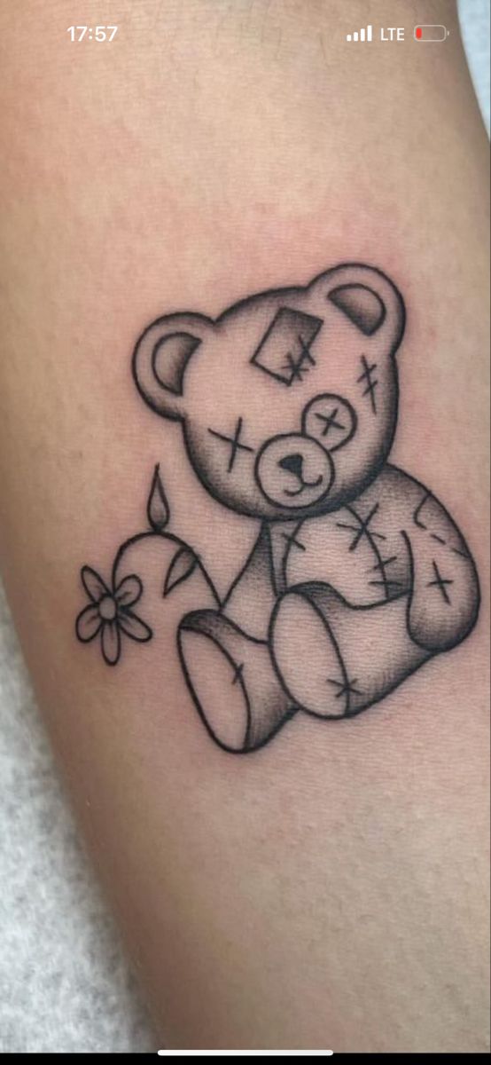 a black and white teddy bear tattoo on the arm