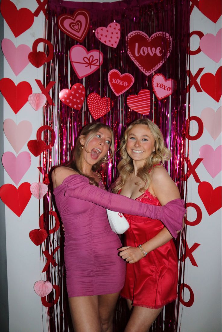 two women are hugging each other in front of valentine's day decorations and streamers