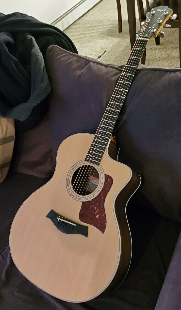 an acoustic guitar sitting on top of a couch