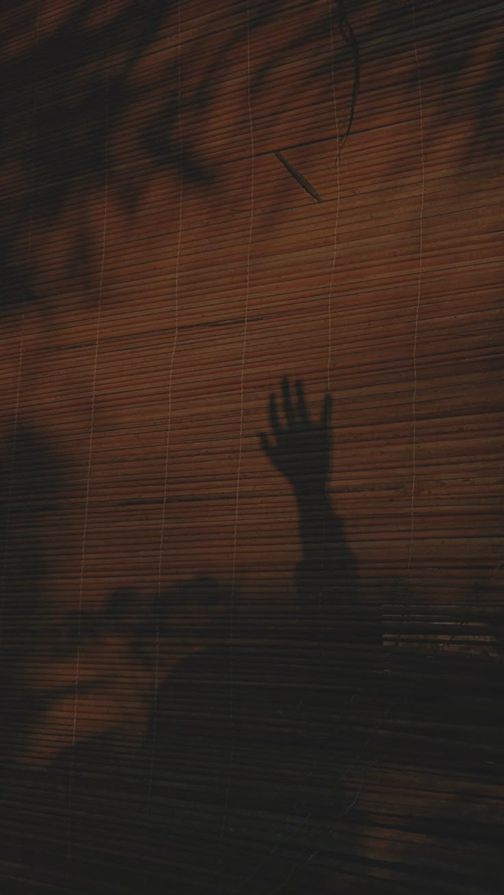 the shadow of a hand reaching up into the air