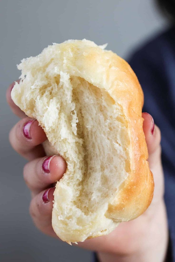 a person holding a piece of bread in their hand