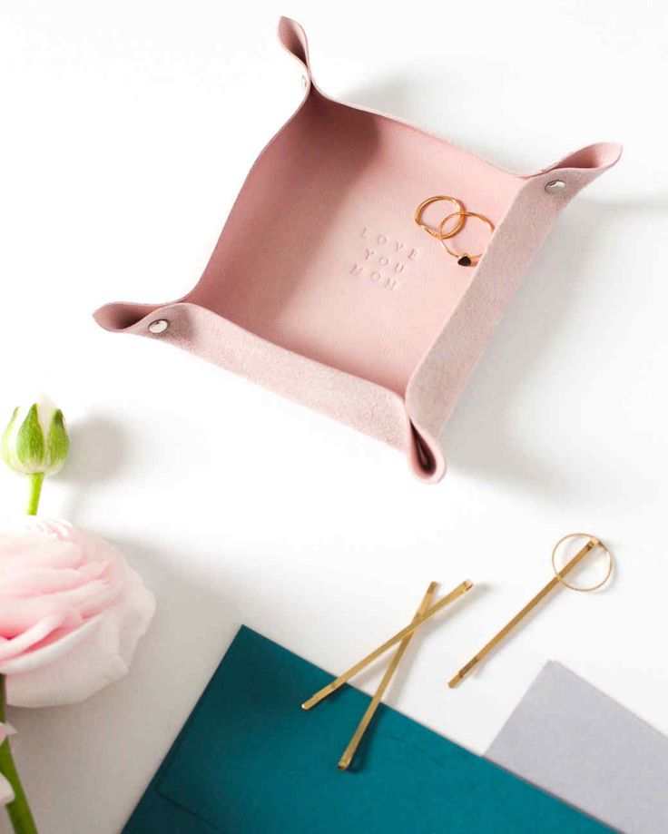 a pink tray sitting on top of a table next to scissors and a vase with flowers