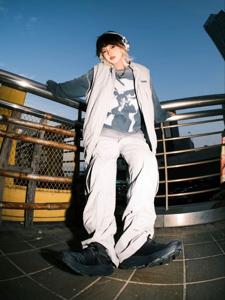 a woman standing on top of a skateboard in front of a fenced area