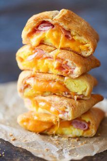 three breakfast sandwiches stacked on top of each other with cheese and ham in the middle