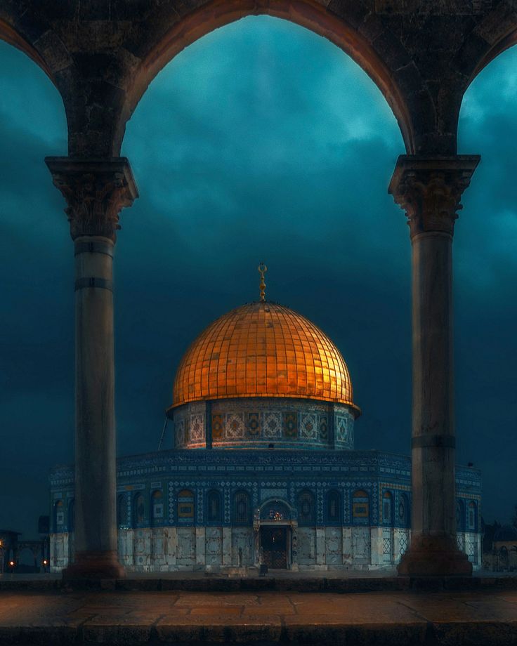 the dome of the rock is lit up at night with clouds in the sky behind it