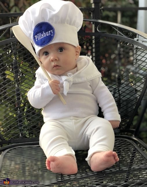 a baby sitting in a chair wearing a chef hat and holding a spatula with the word millbury on it