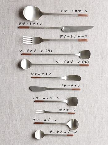 spoons and forks with japanese writing are arranged in a row on a white surface