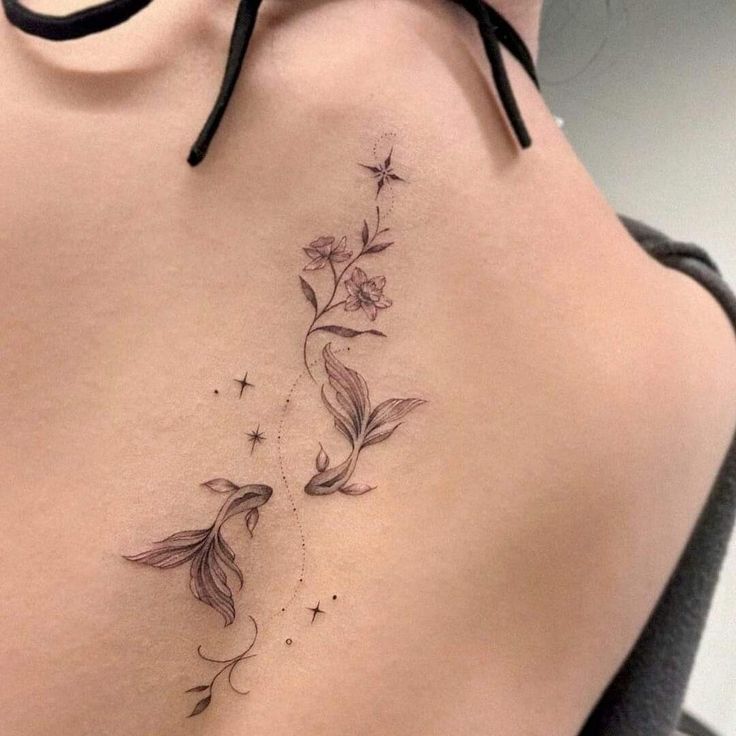 a woman's back tattoo with flowers and stars on her left side ribcage