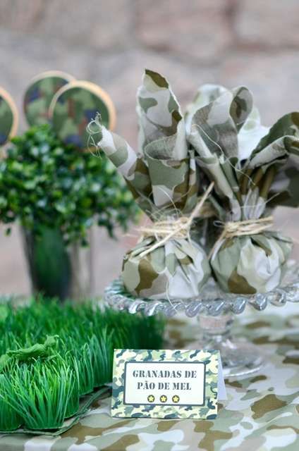 a table topped with green grass next to small vases filled with flowers and greenery