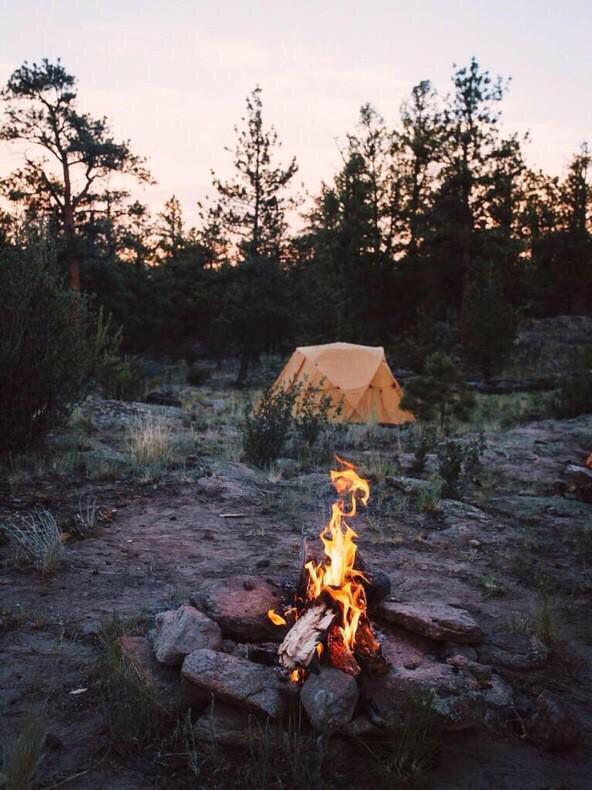 a campfire with a tent in the background