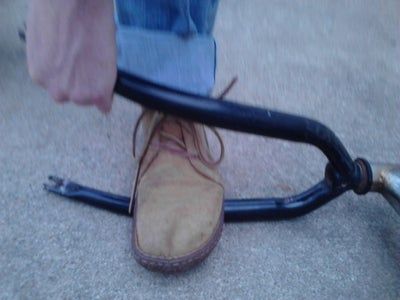 a person riding a scooter with their foot on the handlebars and shoes