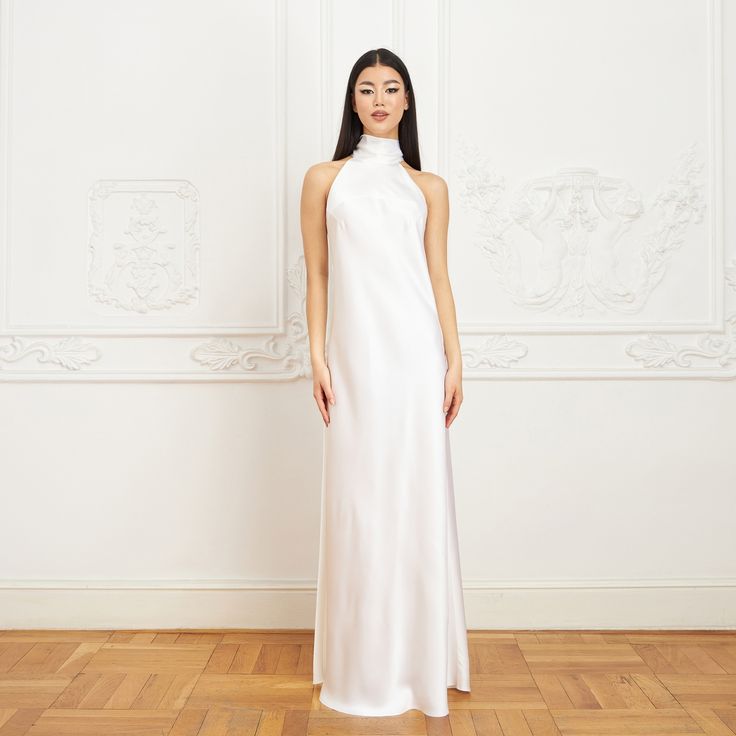 With its modern yet timeless appeal, the Jasmine Halterneck Silk Dress showcases Il Volo’s elevated approach to ready-to-wear. Crafted from white double silk satin in a flattering bias cut, it drapes elegantly over the silhouette. For a playful and feminine look, you can transform the silk tie neck into a chic bow, or you can let it drape loosely, adding a touch of laid-back sophistication to your ensemble.  Wear it with flats for an effortlessly refined look or dress it up with a precious pair White Silk Satin Chic Dress, Chic White Silk Satin Dress, White Satin Evening Slip Dress, Chic White Satin Formal Dress, White Satin Formal Slip Dress, White Silk Satin Evening Dress, White Silk Satin Dress For Formal Occasions, Formal White Satin Slip Dress, Elegant White Satin Silk Dress